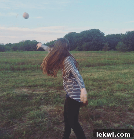 Autumn Harvest: Johnson's Organic Garden Tour and Potluck 9 A person enjoying the fun activity of throwing honeydew melons at the farm, marking the end of their season.