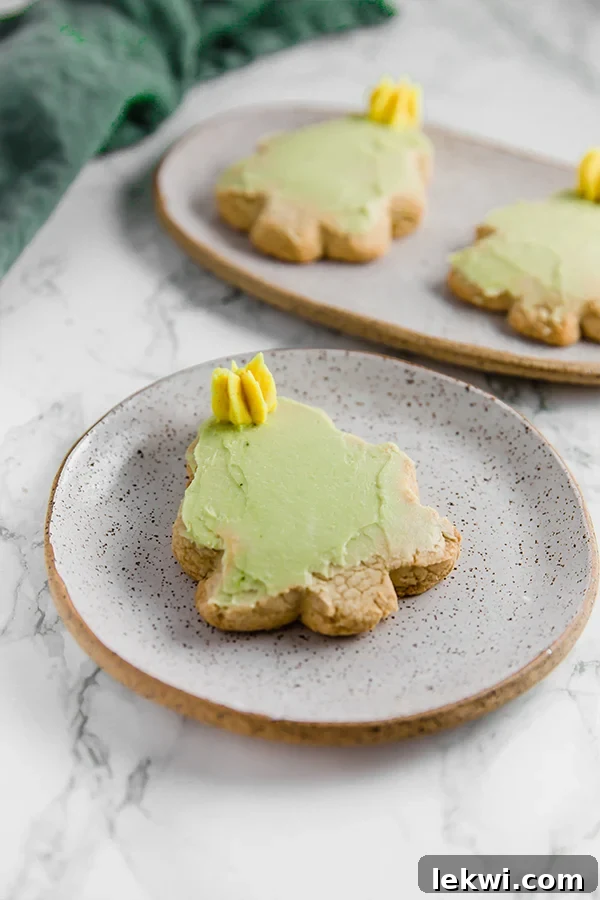 A grey speckled plate with a Christmas tree sugar cookie cut out with green icing and a yellow star on it.