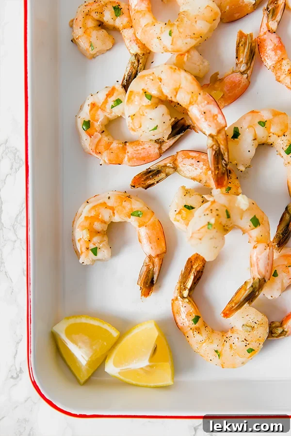 Close-up of golden brown lemon baked shrimp with fresh herbs, ready to be served.