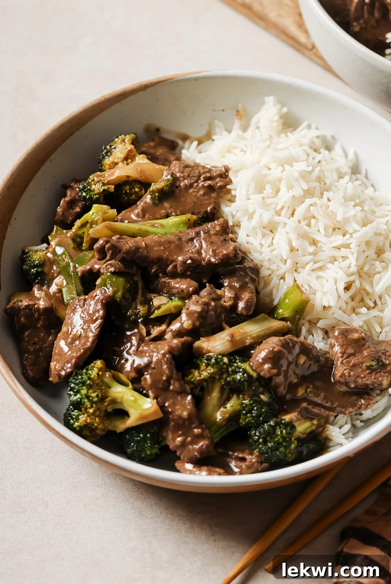 Gluten-free Mongolian beef and broccoli with a side of rice in a bowl.