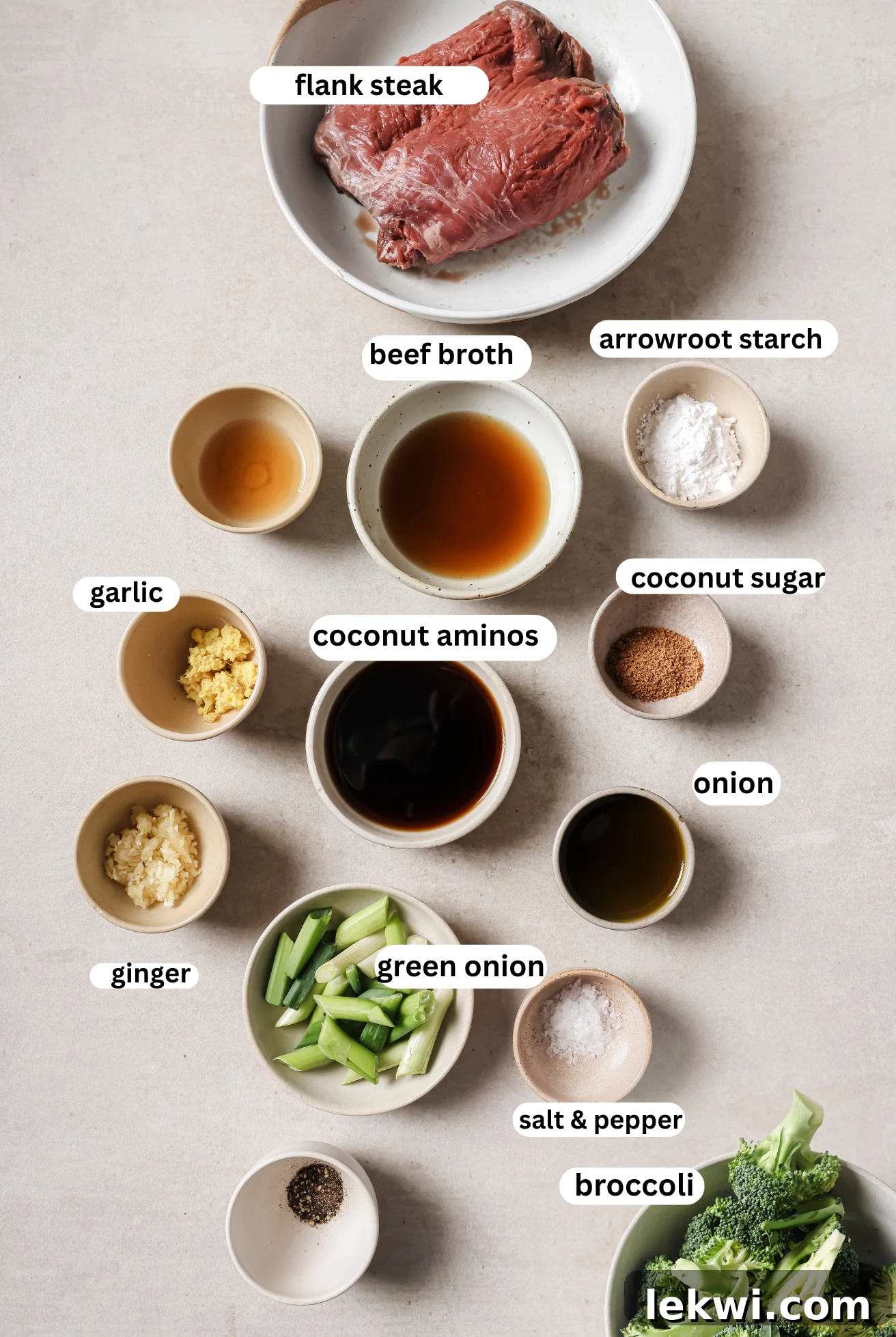 Mongolian beef ingredients laid out in separate dishes, including sliced beef, sauce components, and broccoli.