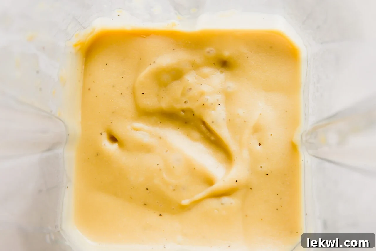 Smooth, creamy vegan queso being blended in a high-speed blender.