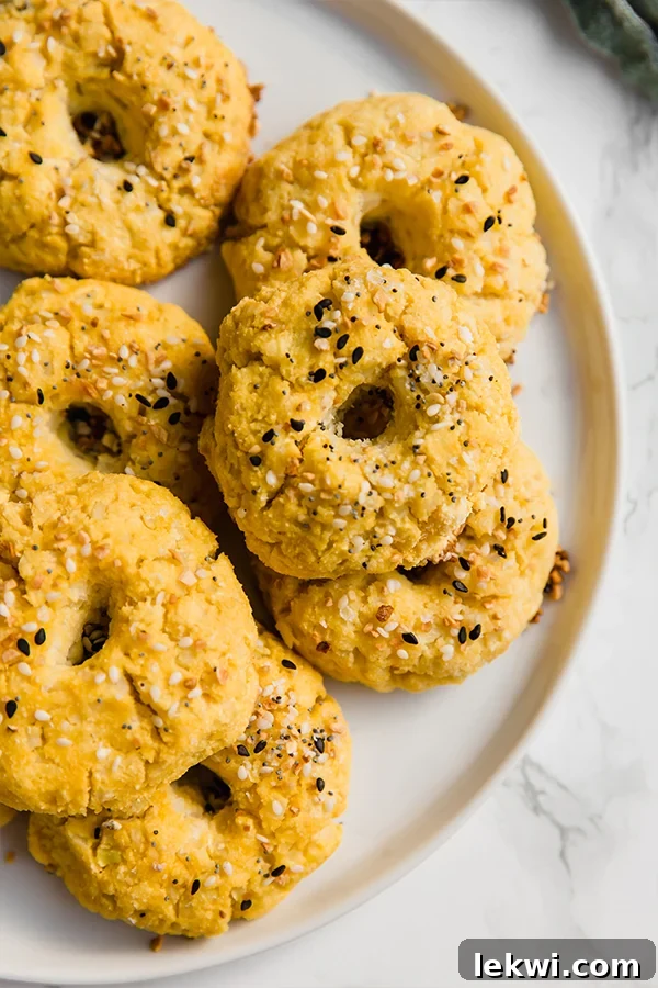 Cauliflower bagel bites seasoned with everything bagel spice, served on a plate.