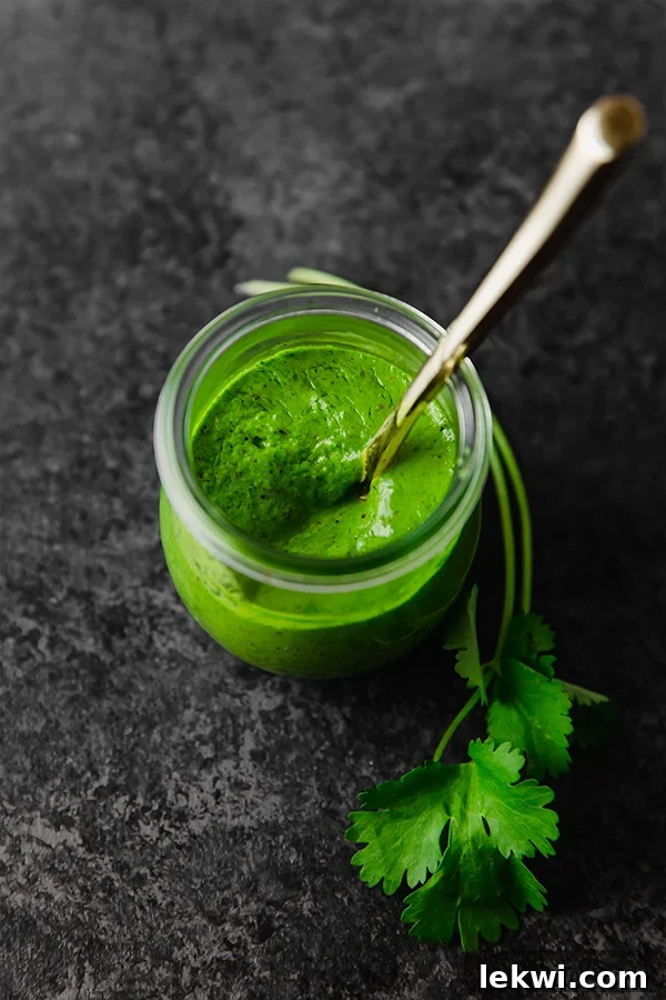 A second shot of a glass jar filled with fresh chimichurri sauce, highlighting its vibrant green color.