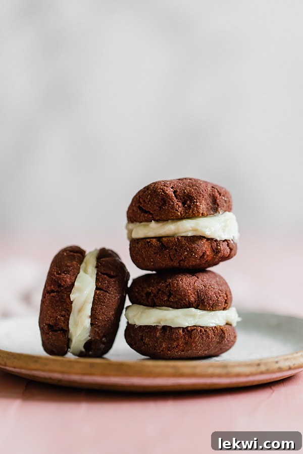 A stack of red velvet whoopie pies with creamy filling.