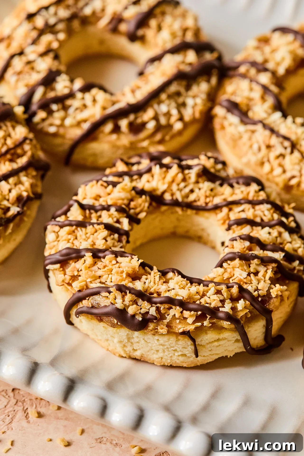 Samoa cookies with chocolate drizzle on a white platter