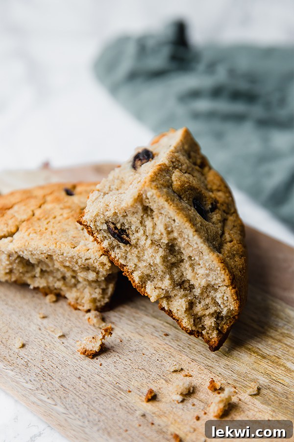 A wooden cutting board with two pieces of Irish soda bread on it.