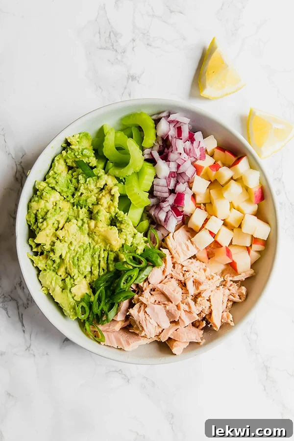 Creamy Avocado Tuna Salad served in a bowl, garnished with fresh herbs.