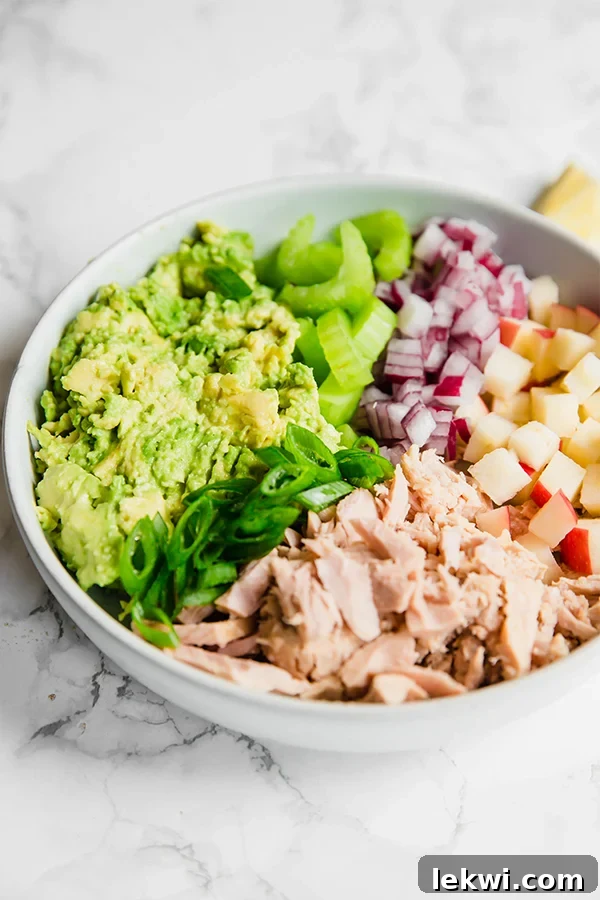 Avocado Tuna Salad with mixed vegetables in a white bowl.