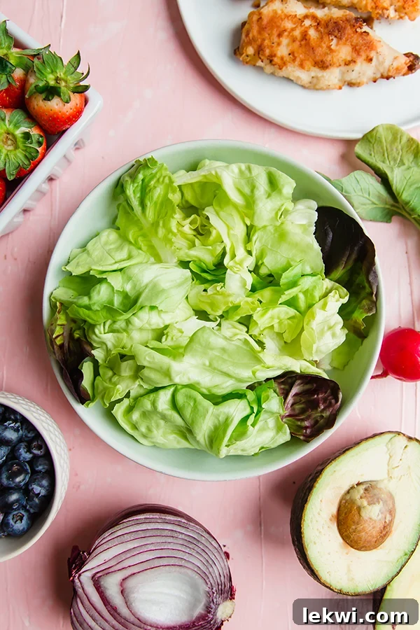 A close-up of the crispy chicken salad, highlighting the perfectly breaded chicken, the vibrant colors of the berries and vegetables, and the creamy avocado ranch dressing, all invitingly presented.
