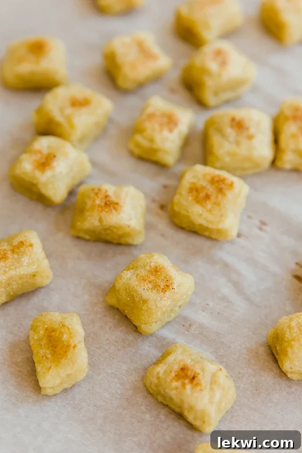 A sheet pan covered in parchment paper with homemade cauliflower gnocchi.