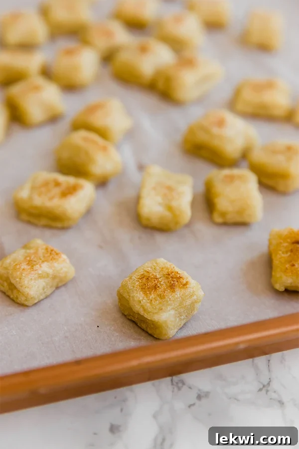 A sheet pan covered in parchment paper with homemade cauliflower gnocchi baking.