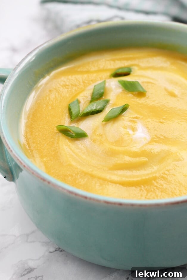 A bowl of butternut squash soup in a blue bowl.