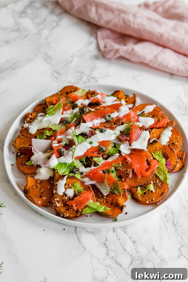 A white plate filled with colorful everything bagel & lox breakfast nachos, ready to be enjoyed.