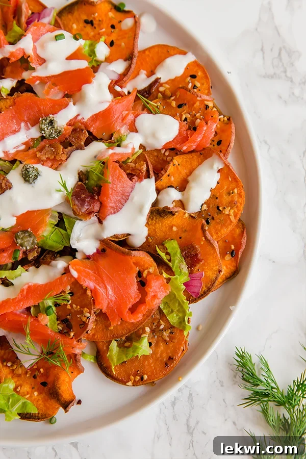 A white plate filled with everything bagel & lox breakfast nachos.