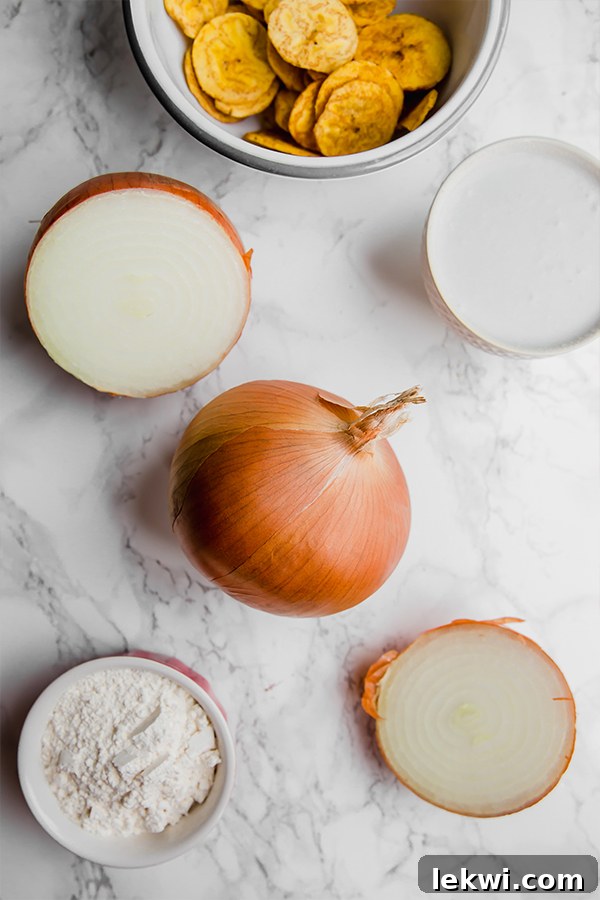 Halved yellow onions on a cutting board, ready for slicing