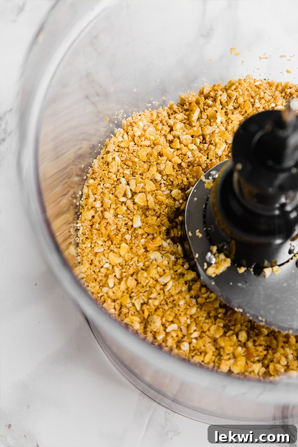 A food processor grinding plantain chips into a fine coating
