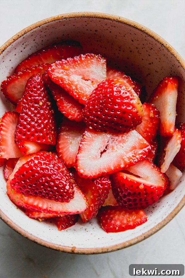 Sliced strawberries in a bowl.