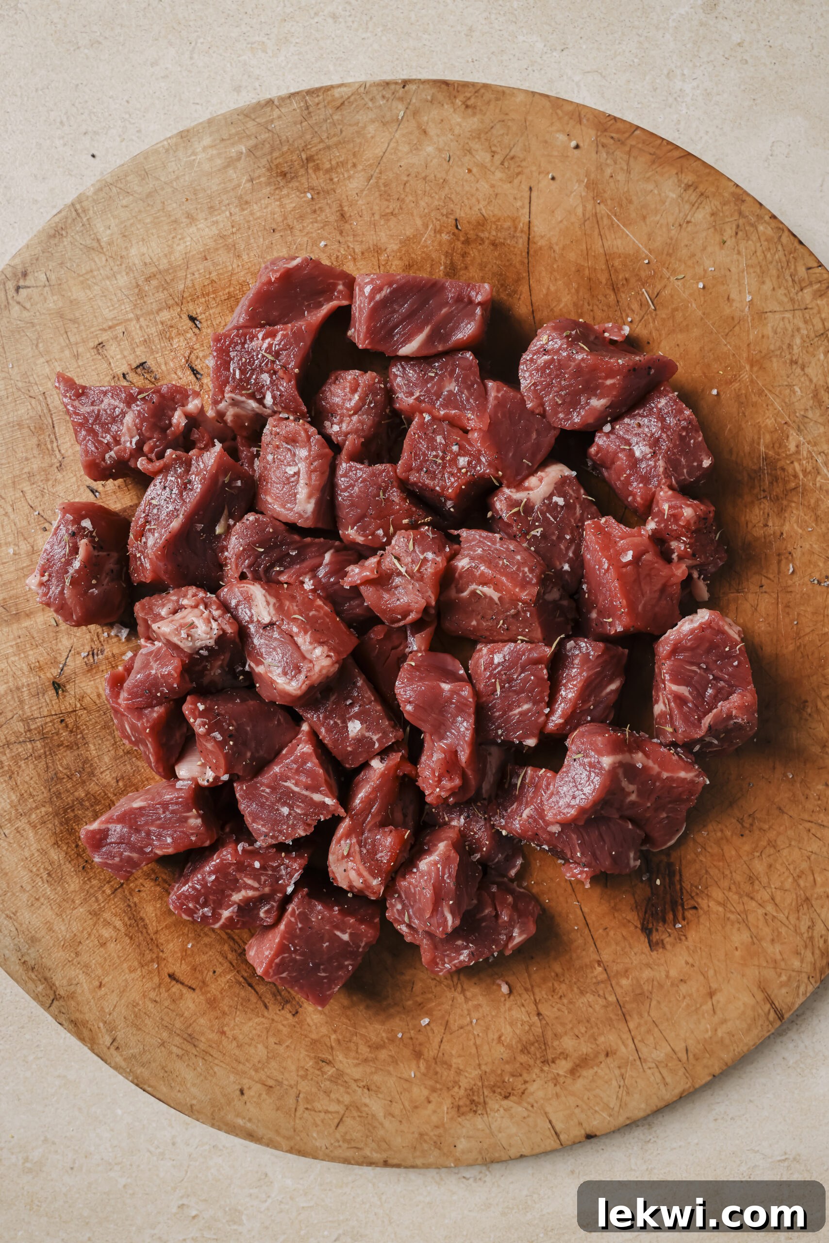 Bite-sized pieces of steak on a wooden board.