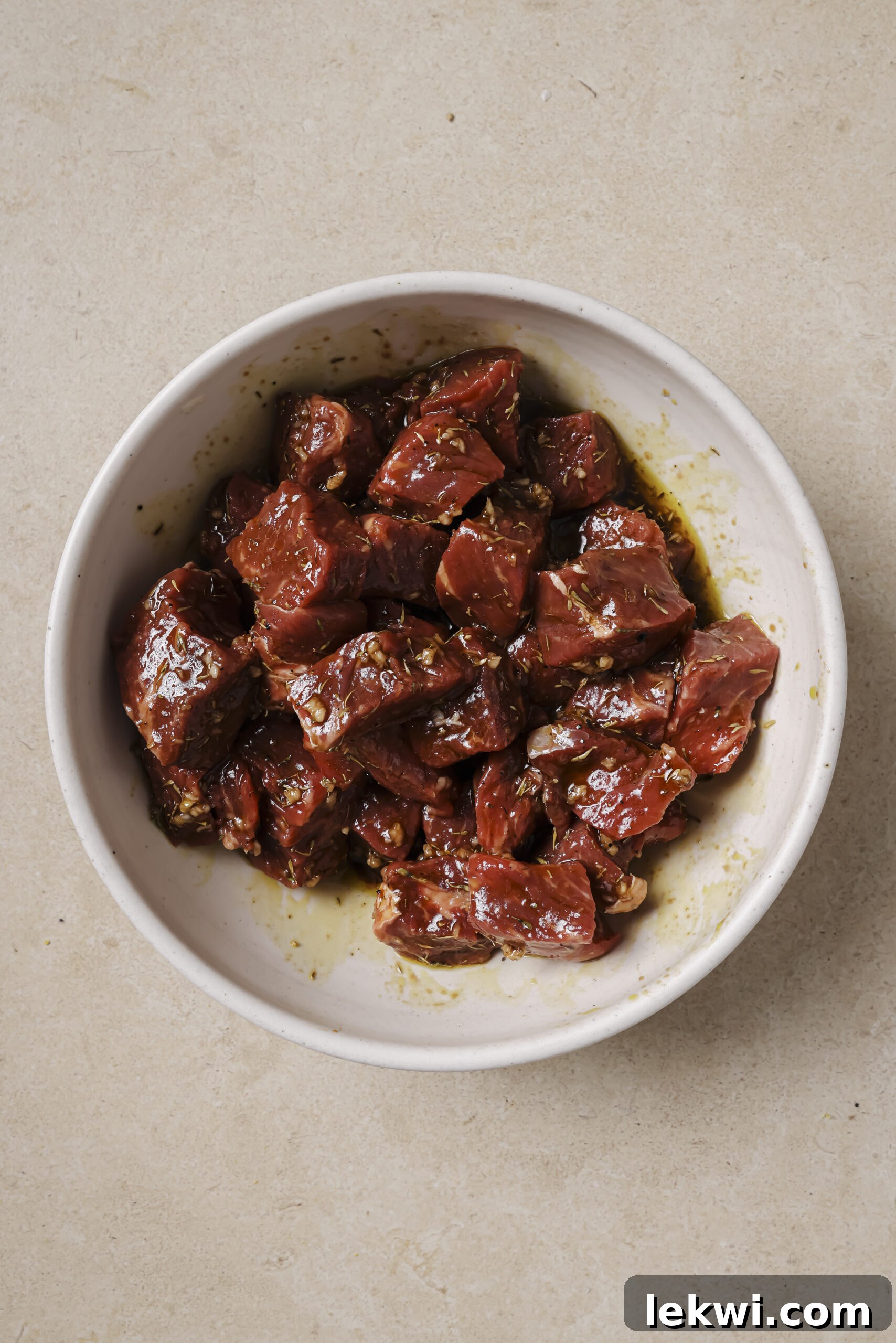 Steak marinating in a balsamic vinegar mixture in a bowl.