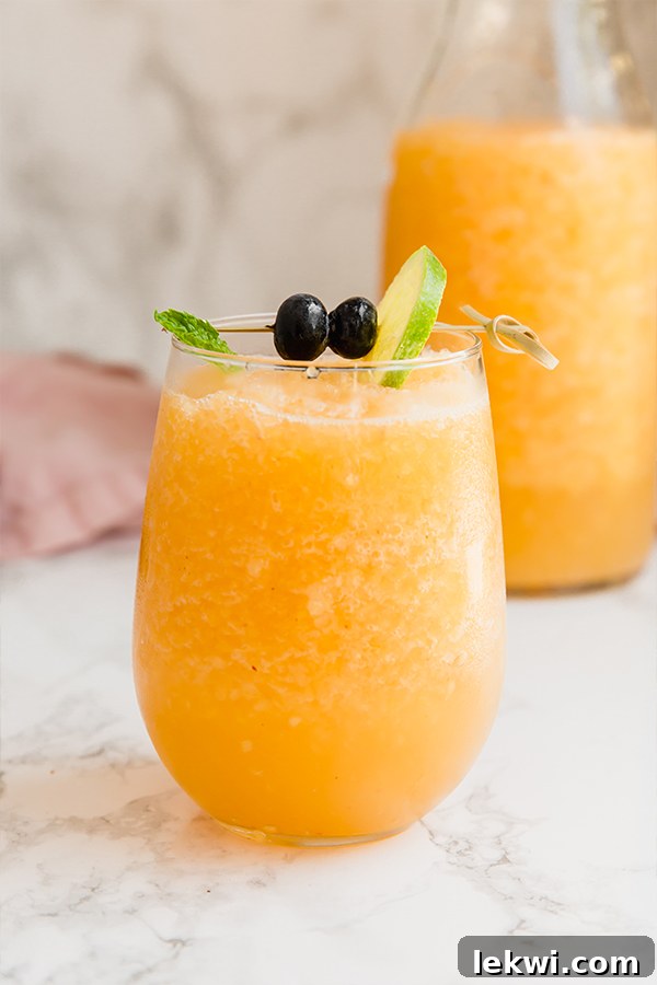Two elegant glasses filled with the vibrant, frozen peach bellini mocktail, perfectly chilled and ready for enjoyment.