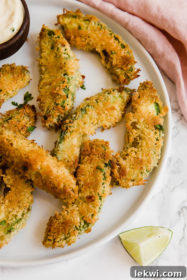 A white plate filled with golden-brown avocado fries.