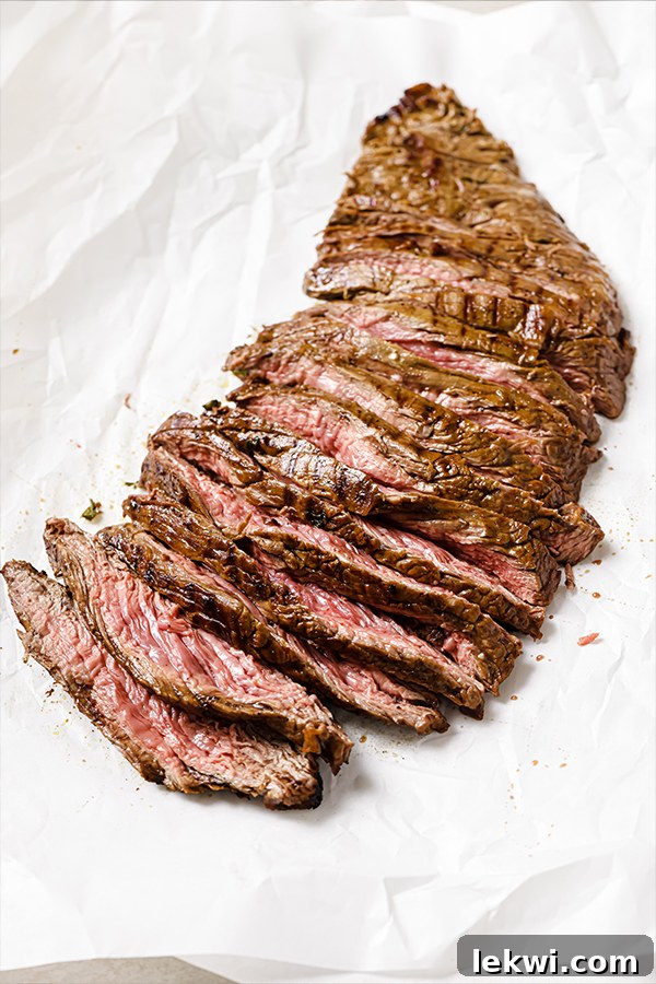 Sliced carne asada on parchment paper.