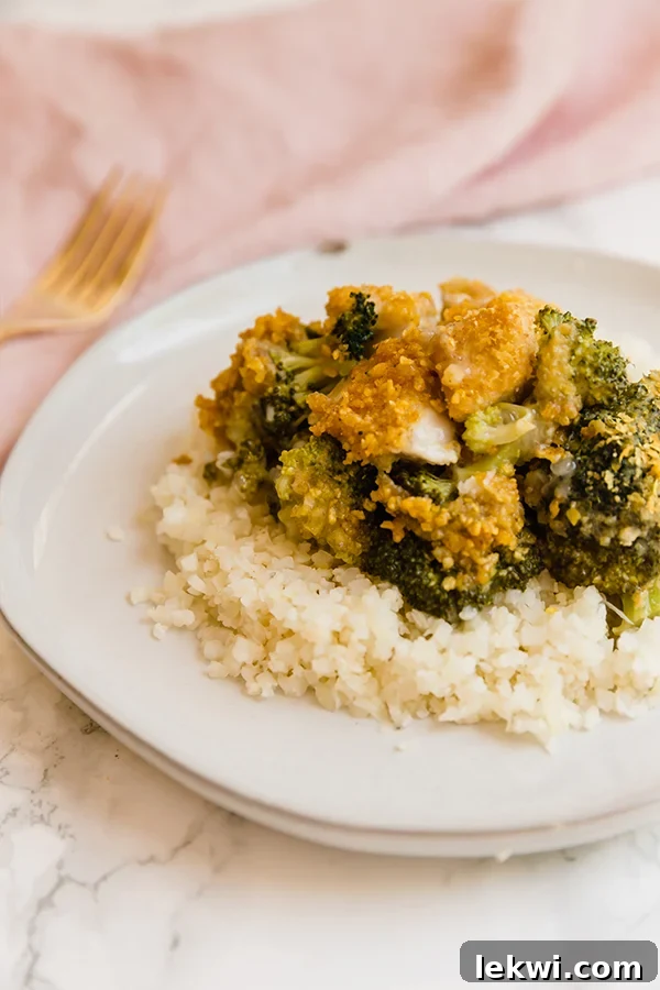 A serving of Paleo Chicken Divan beautifully plated over a bed of cauliflower rice.