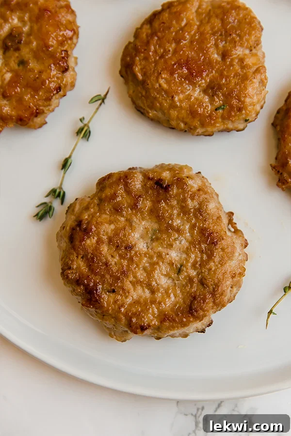 Plated turkey maple breakfast sausages with fresh herbs, showcasing a healthy and compliant meal.