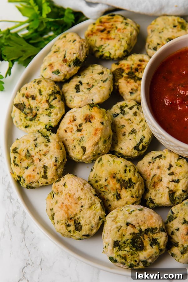 A plate filled with Italian chicken poppers and dipping sauce in the middle.
