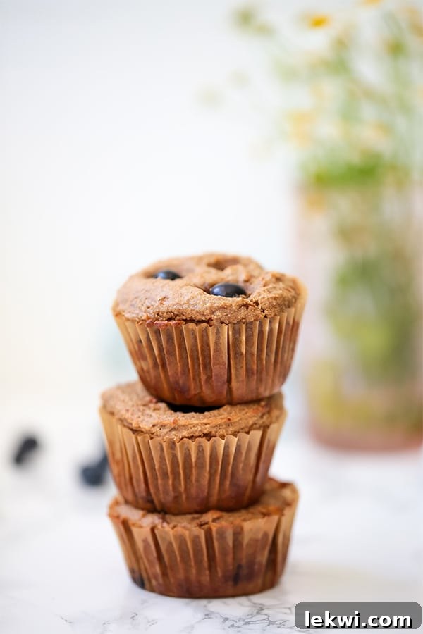 A delightful stack of golden blueberry banana muffins, artfully arranged to showcase their inviting texture and generous blueberry inclusions.
