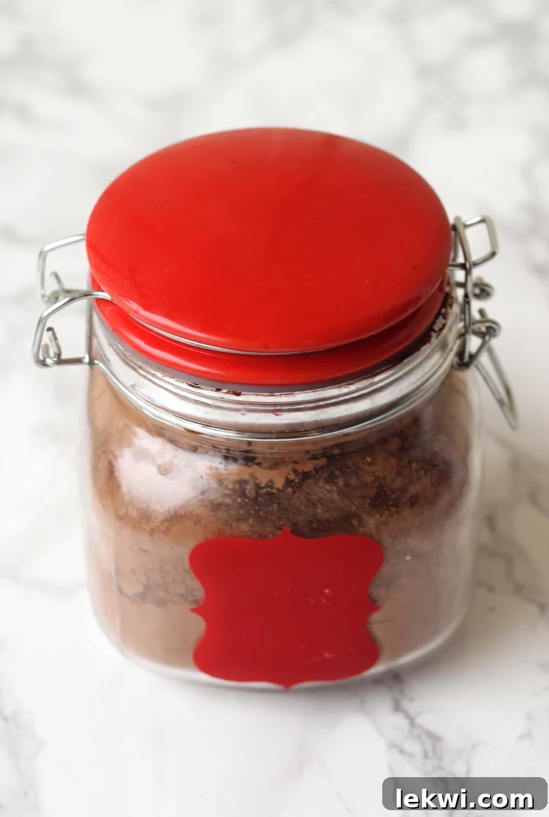 Hot chocolate in a white and red canister. The canister is filled with carob powder.