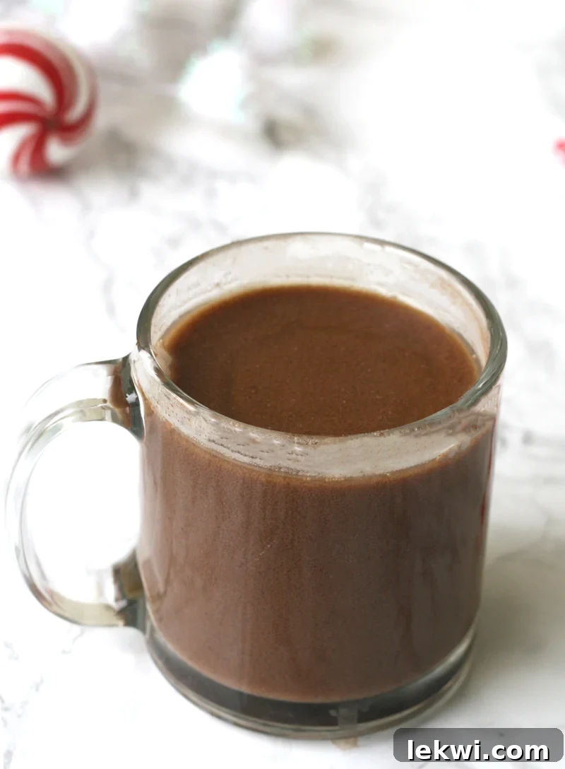 AIP Hot Chocolate (Paleo, AIP, Dairy Free) served in a white mug with a festive background.