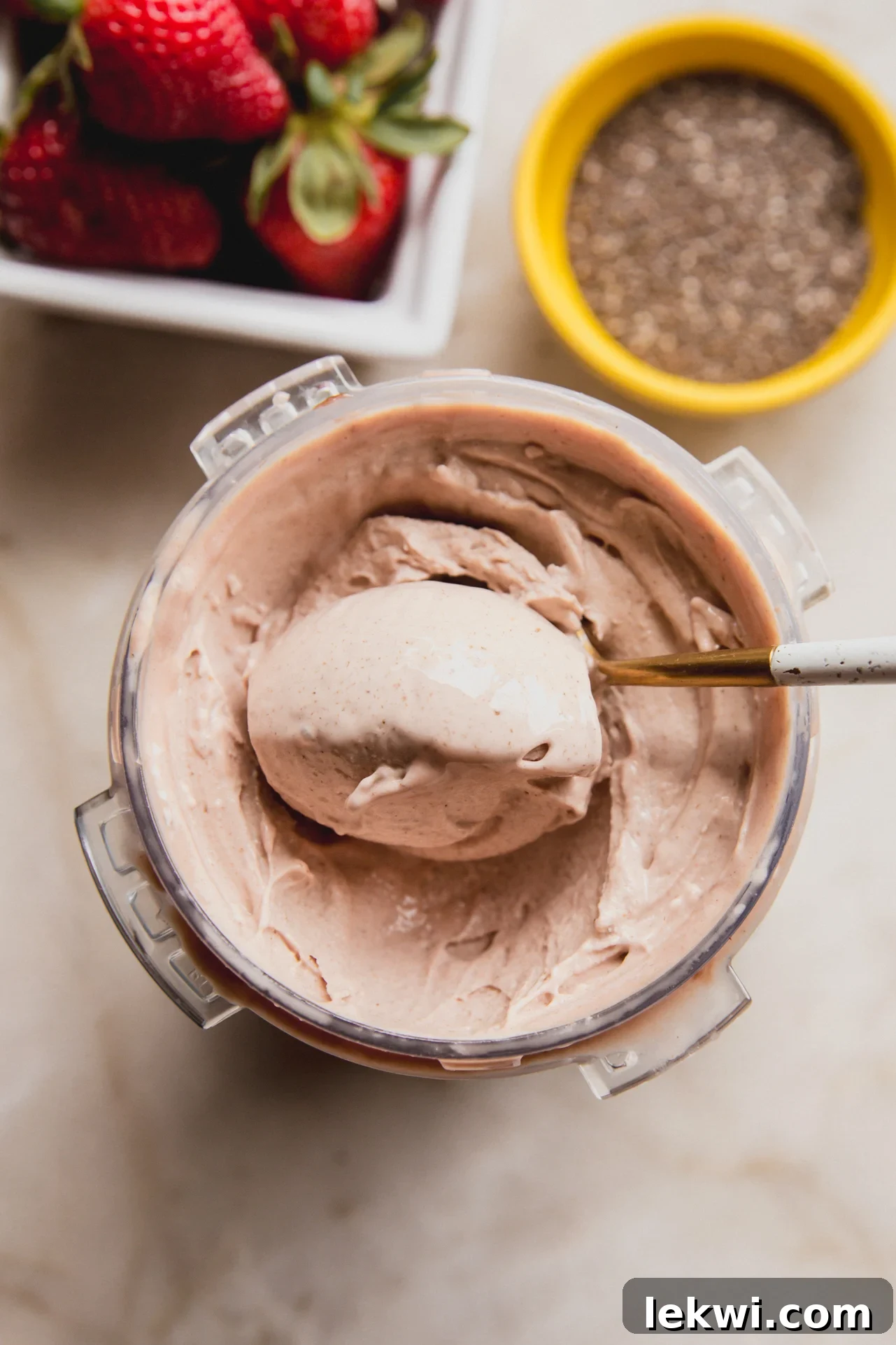 A overhead shot of the Ninja Creami pint of chia seed ice cream with a spoon taking a spoonful out.