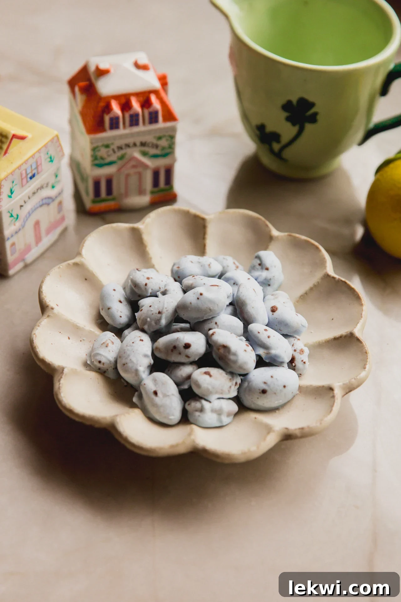 Robin's Egg Chocolate Covered Almonds 2 Blue chocolate covered almonds with brown speckles in a bowl with spring kitchen decor in the background.
