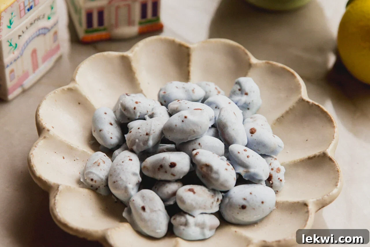 Robin's Egg Chocolate Covered Almonds 6 Blue chocolate covered almonds with brown speckles in a bowl with spring kitchen decor in the background.