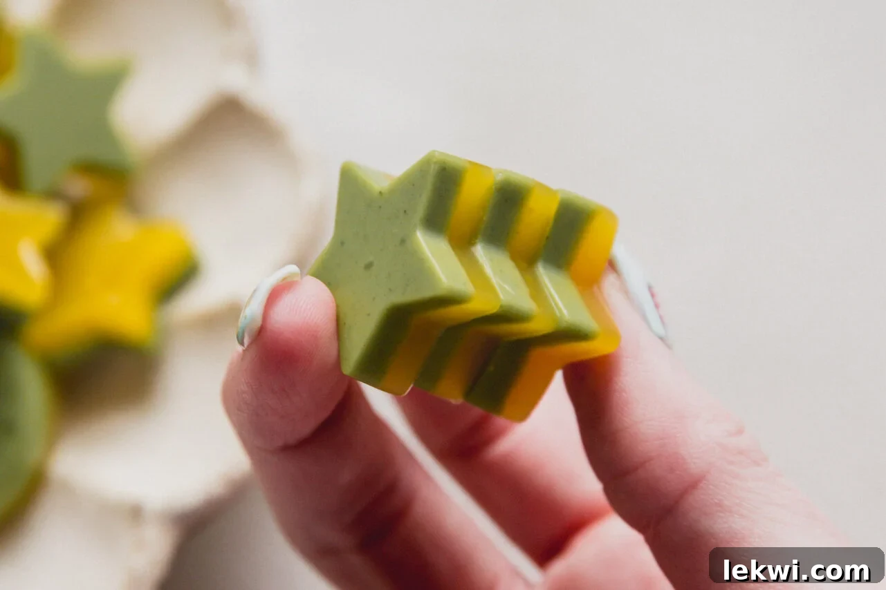 Chewy Matcha Mango Delights 10 A hand holding mango matcha gummies in it.