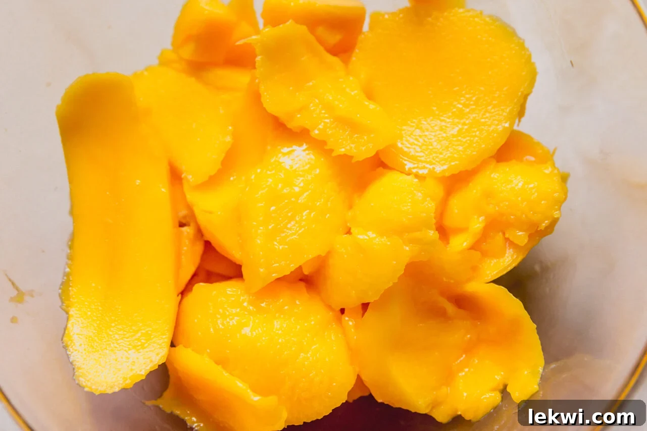 Tropical Mango Coconut Posset 5 A blender filled with mango chunks before being pureed to a smooth consistency.