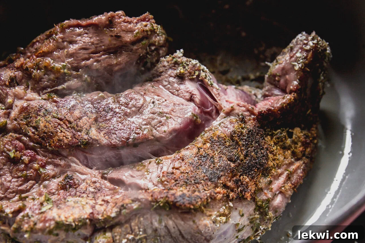 A Dutch oven with a chuck roast searing in it, showing a beautifully browned crust.