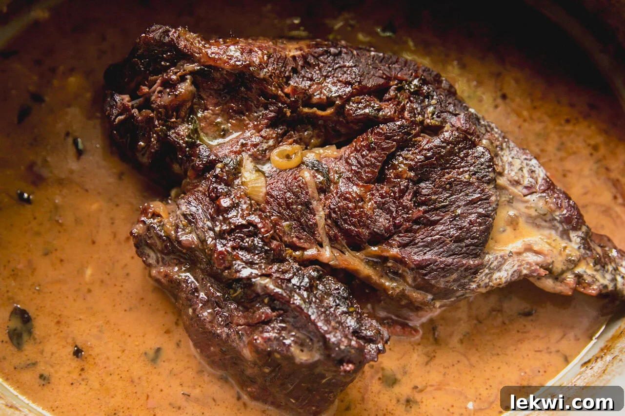 The Dutch oven with the seared chuck roast removed, showing the pan being deglazed with vinegar.