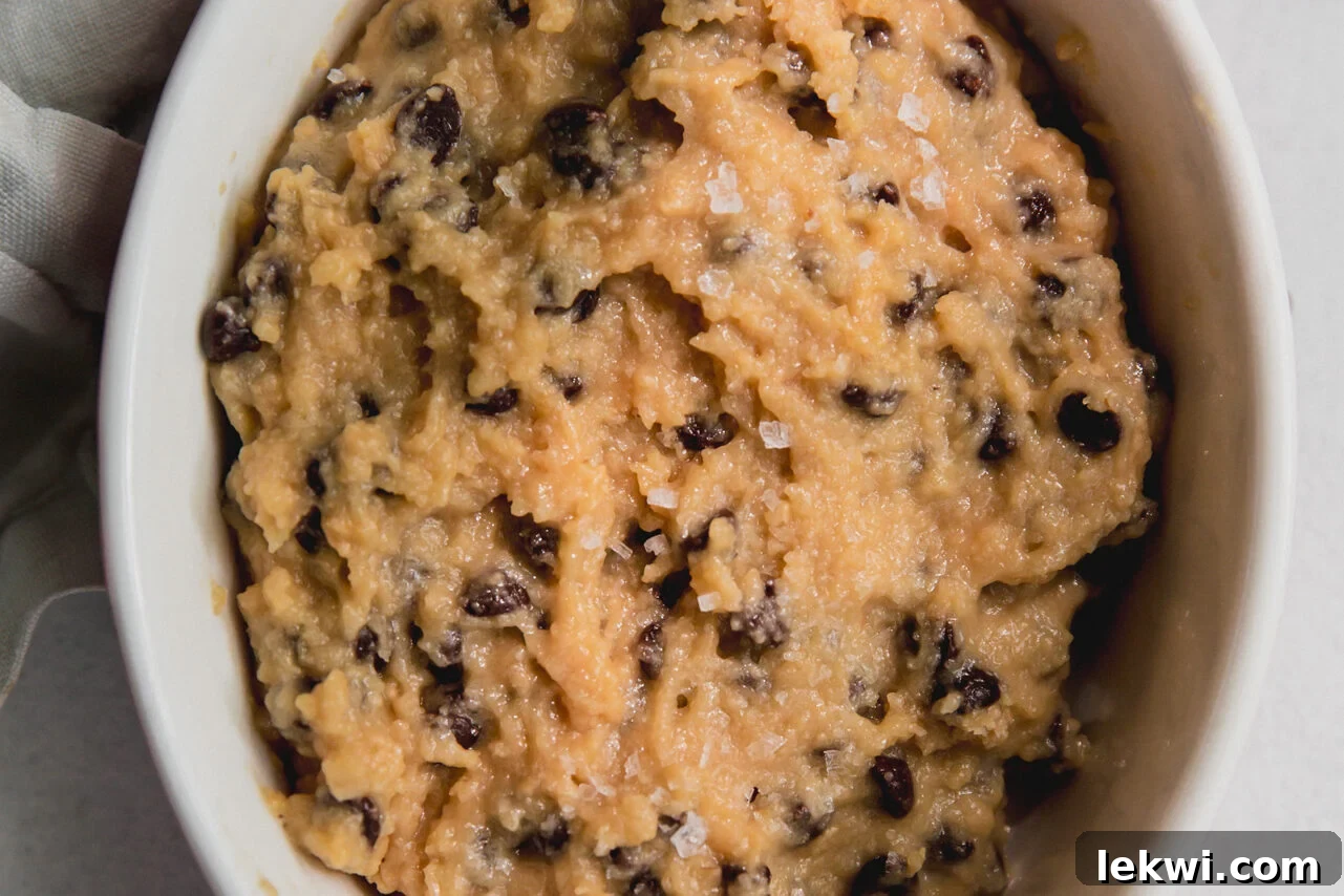 Finished protein cookie dough in a pink bowl topped with sea salt.