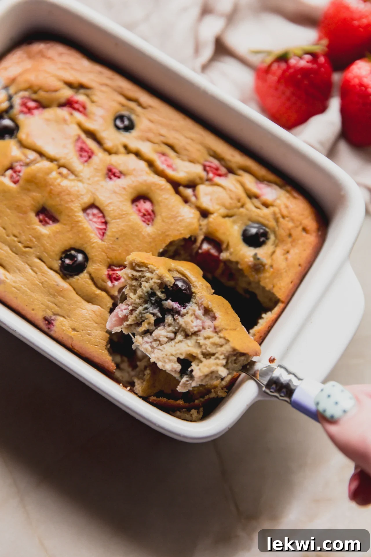 Berry Protein Breakfast Cake: High-Protein Morning Berries Bake 9 A spoon taking a scoop out of the berry protein breakfast cake.