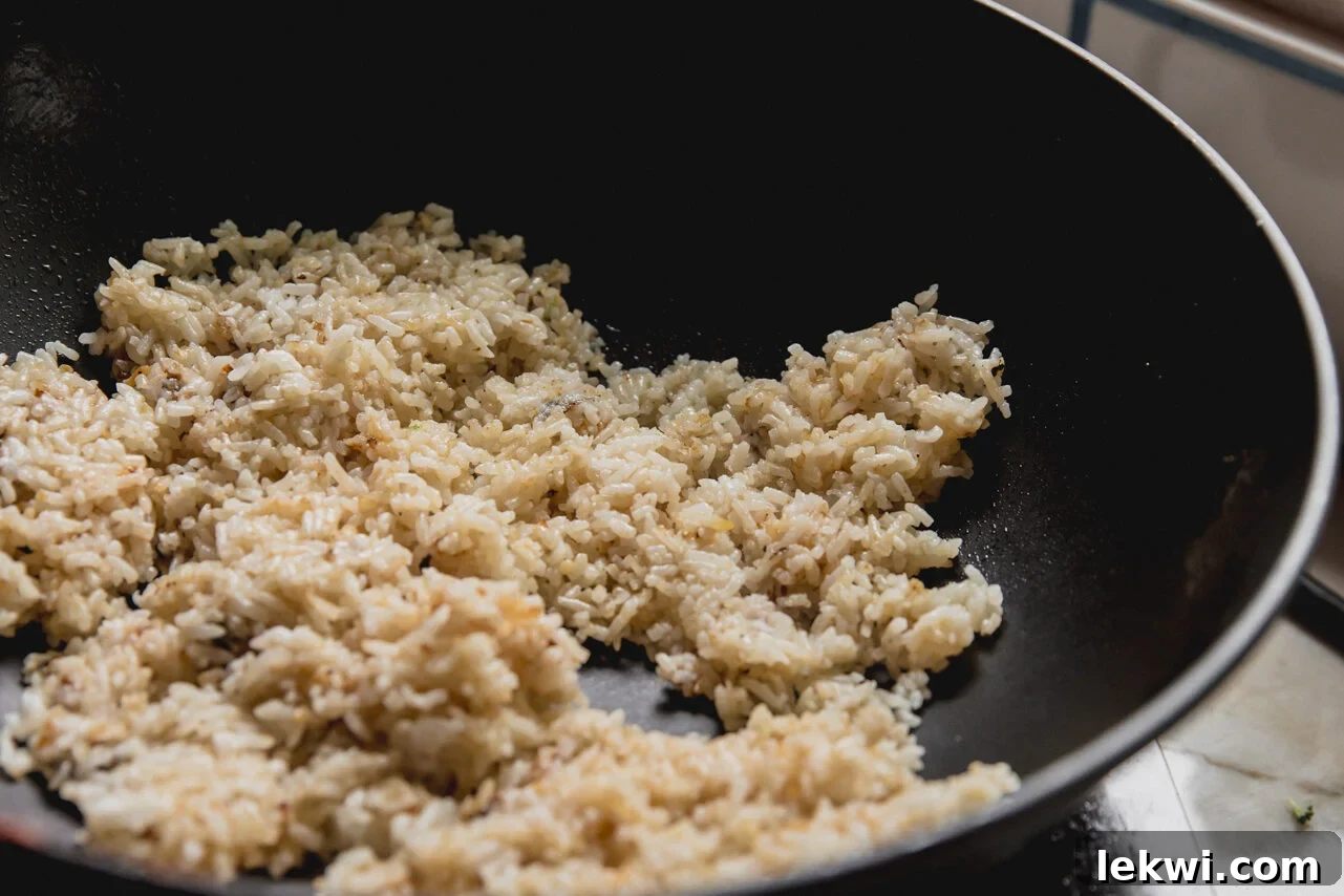 A wok filled with rice heating in it.