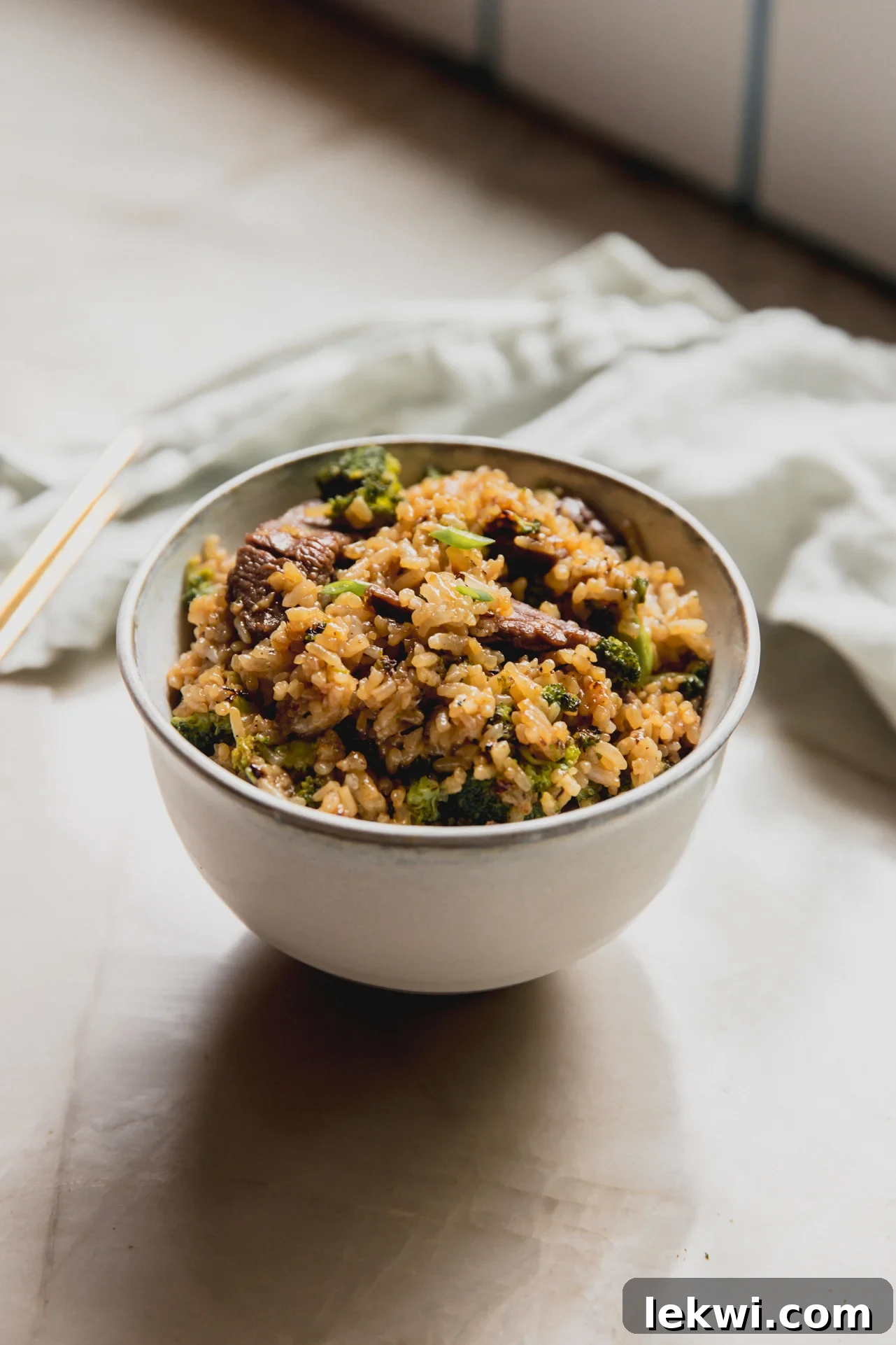Beef and broccoli fried rice in a small white bowl.