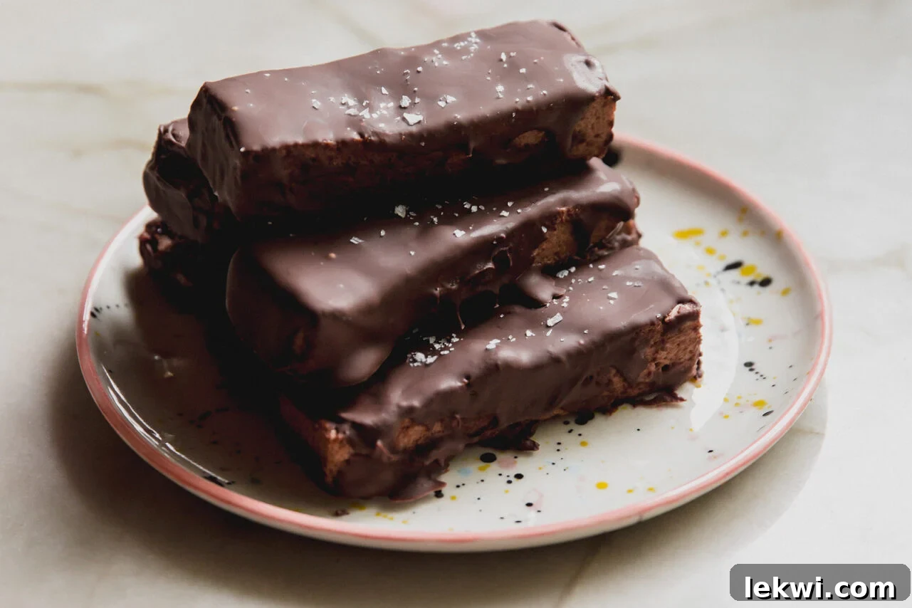 Brownie marshmallow protein bars stacked on top of each other on a plate.