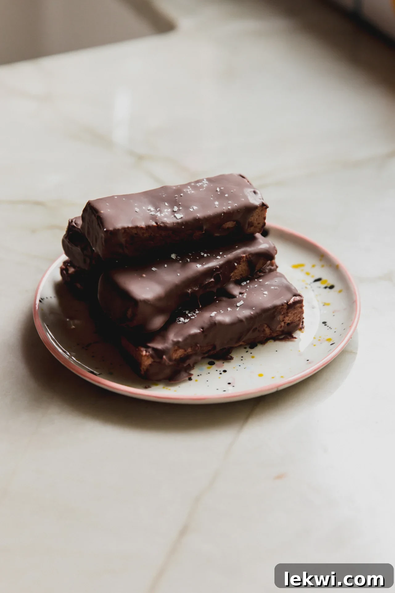 Brownie marshmallow protein bars stacked on top of each other on a plate. 