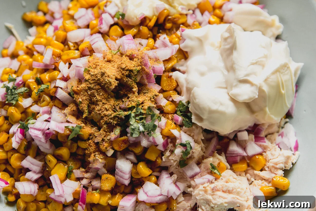 A bowl filled with all the ingredients to make street corn chicken salad before combining.