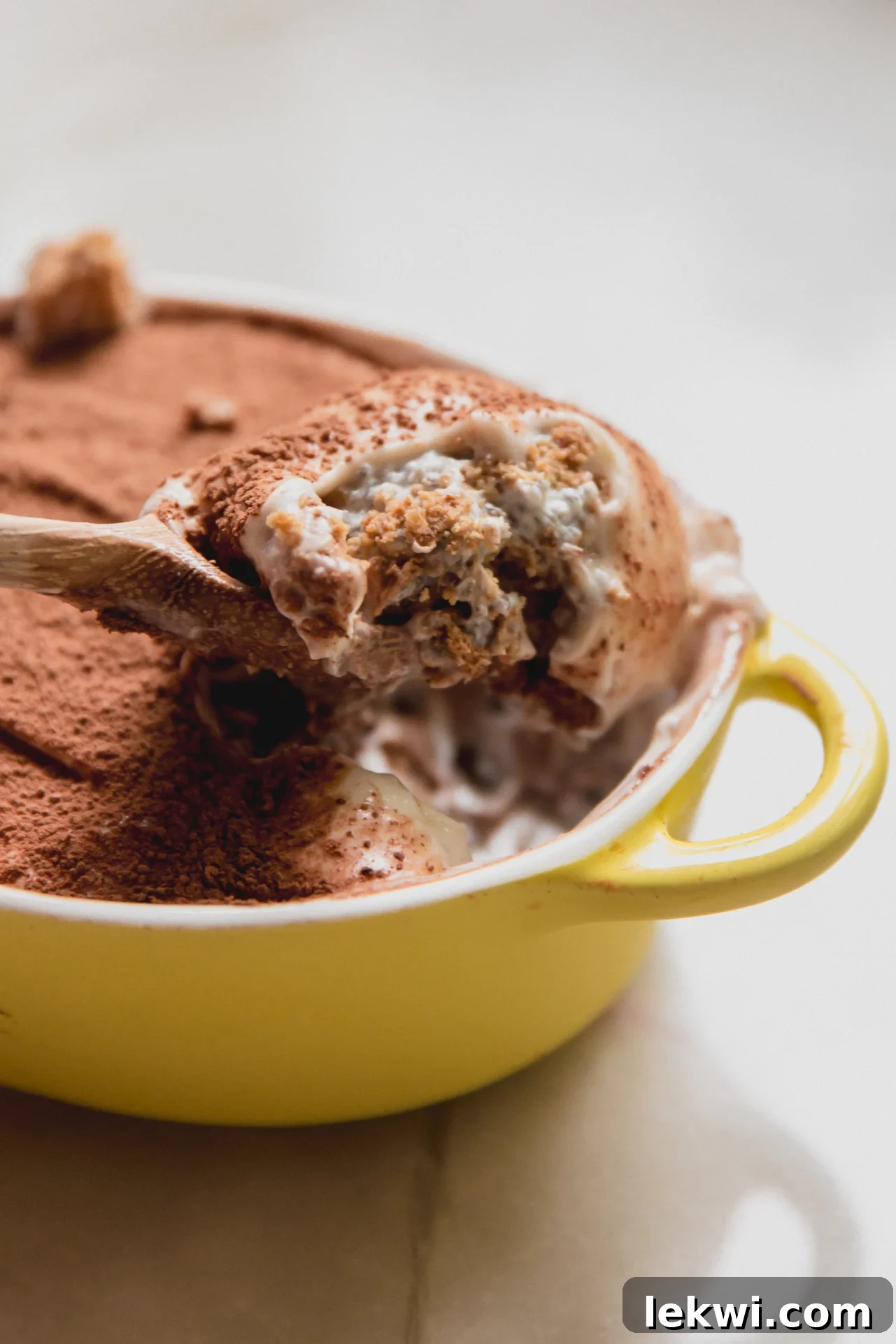 Gluten-Free Protein Tiramisu Recipe: High-Protein Dessert Without Gluten 2 Protein tiramisu in a small yellow dish with a spoon scooping out a scoop.