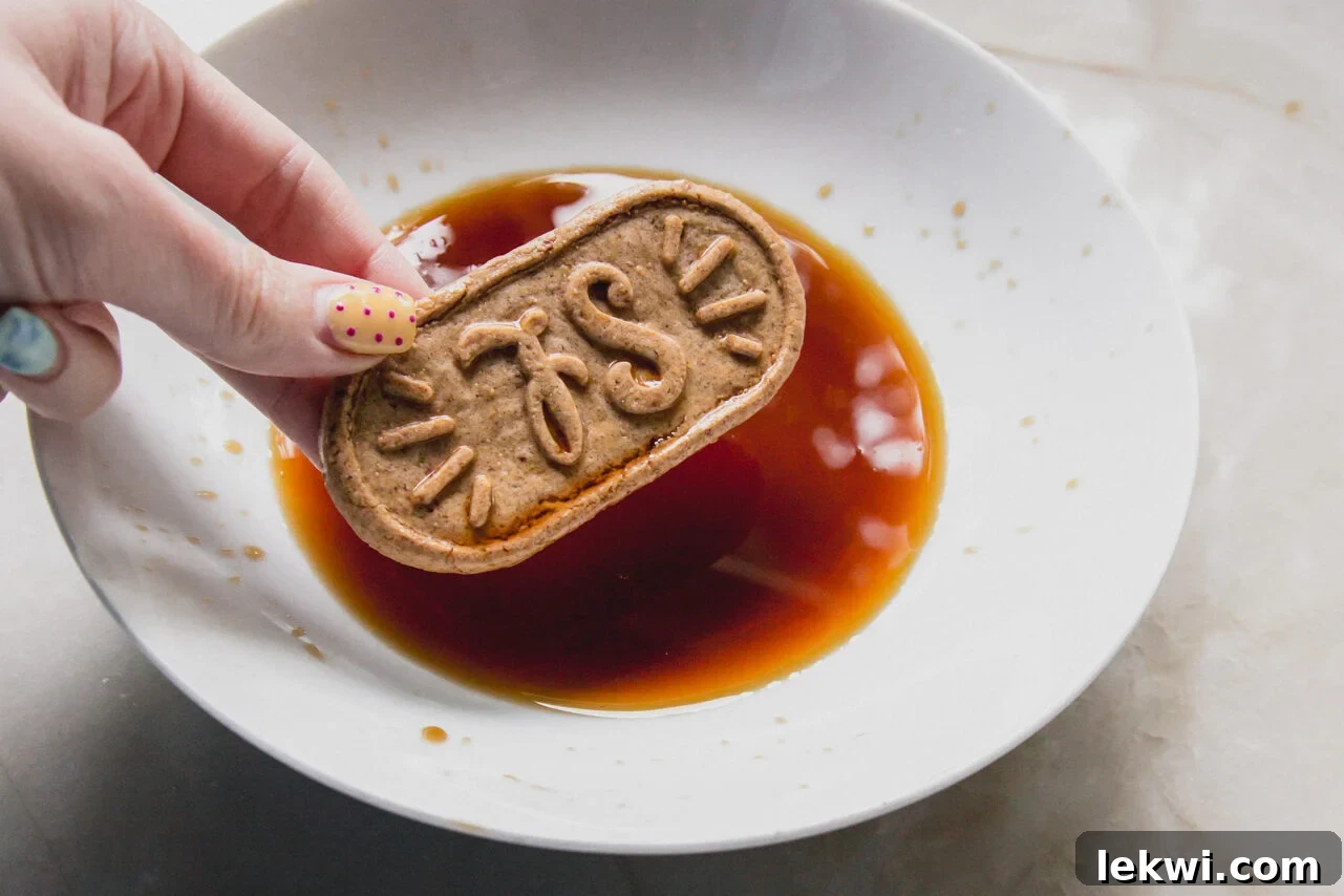 Gluten-Free Protein Tiramisu Recipe: High-Protein Dessert Without Gluten 5 A breakfast biscuit being dipped into coffee in a white bowl by a hand.