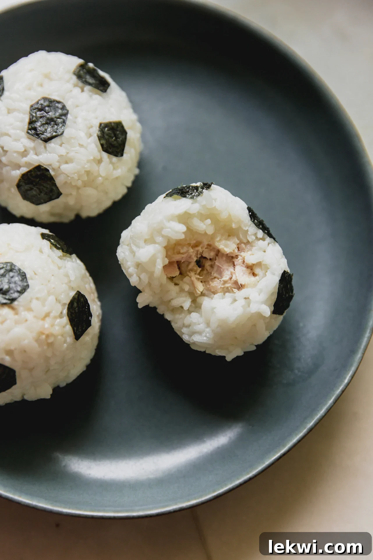 Three soccer-style rice balls on a plate.